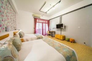 安平的住宿－莫非輕旅，酒店客房设有两张床和一台平面电视。