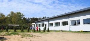 a white building with a person standing in front of it at Kihnu Sadama Öömaja Guesthouse in Lemsi