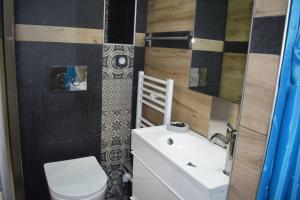 a bathroom with a white toilet and a sink at h2h Anthi Comfort apt near Athens in Athens +15 photos