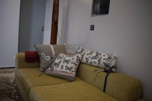 um sofá com almofadas na sala de estar em 3h Anthi Comfort apt near Athens em Atenas