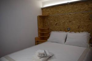 a white bed with a towel on top of it at h2h Anthi Comfort apt near Athens in Athens