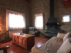 Cal Mateuet في Traveseres: غرفة معيشة مع أريكة ومدفأة