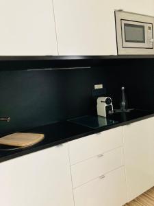 a kitchen with white cabinets and a microwave at Maxhof Trier in Trier