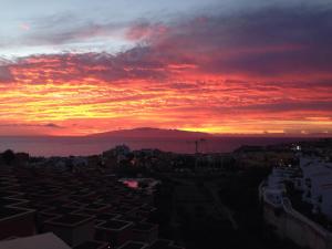 a sunset over a city with a mountain in the background at Dream View in Adeje