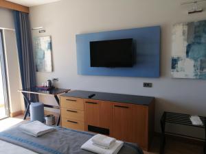 a bedroom with a bed and a television on the wall at Doğruer Hotel & Spa in Muğla