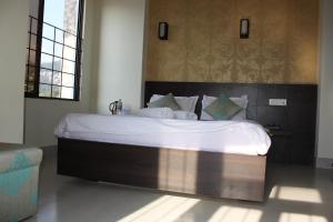 um quarto com uma cama grande e lençóis brancos em Mystic Valley Gangtok em Gangtok