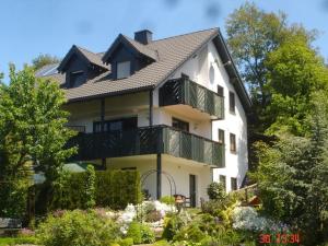 a large white house with a balcony at Ferienwohnung Sonnenhang-Hartmann in Olsberg