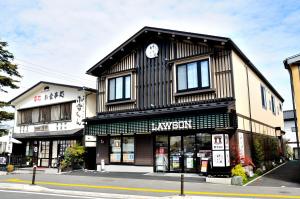 a black and white building with a clock on it at Oyado Yukizumi in Kusatsu