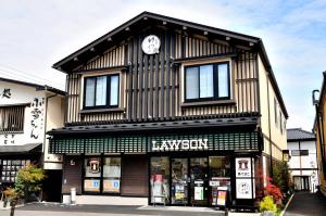 a black and white building with a clock on it at Oyado Yukizumi in Kusatsu
