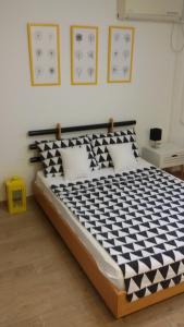 Un dormitorio con una cama con un edredón blanco y negro. en Dandelo, en Novi Sad