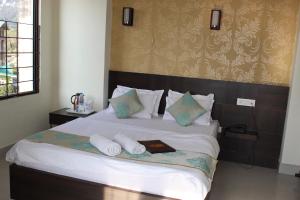 um quarto com uma cama grande com lençóis brancos e almofadas em Mystic Valley Gangtok em Gangtok