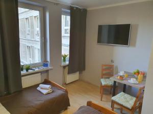 a room with a bed and a table and a window at Jasna Hotelik in Warsaw