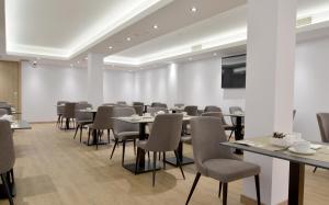 a conference room with tables and chairs and a screen at UVE Marcenado in Madrid