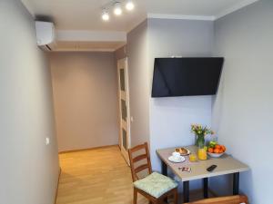 a dining room with a table and a tv on the wall at Jasna Hotelik in Warsaw
