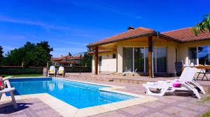 a swimming pool with chairs and a house at Вила Релакс - Villa Relax in Sokolovo