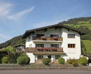 a white building with balconies and flowers on it at Appartements Charlotte in Westendorf