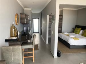 Apartment 32, BAY VIEW SUITES في Langstrand: غرفة نوم مع سرير ومكتب مع مكتب