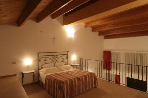 um quarto com uma cama num quarto com tectos em madeira em Masseria Casacapanna em Chieuti