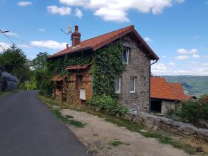 a stone house with ivy on the side of a road at Gîte de la Meille in Chamalières-sur-Loire