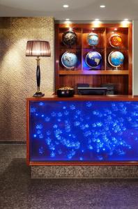 un grande acquario blu in una stanza con una lampada di 25hours Hotel The Goldman a Francoforte sul Meno