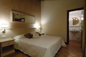 um quarto com uma cama, um espelho e um lavatório em Albergo CAVALLINO 10 em Toscolano Maderno