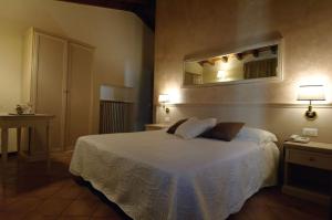 a bedroom with a bed and a mirror on the wall at Albergo CAVALLINO 10 in Toscolano Maderno