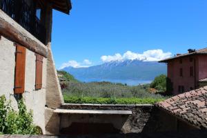 - une vue sur les montagnes et l'eau depuis un bâtiment dans l'établissement Albergo CAVALLINO 10, à Toscolano Maderno