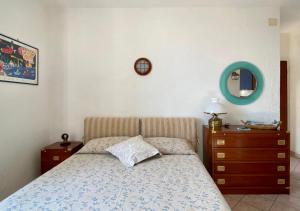 a bedroom with a bed and a dresser and a mirror at Lilli's House in Porto Santo Stefano