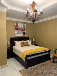 a bedroom with a large bed and a chandelier at Kimberley Boutique Guest Lodge in Kimberley