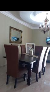 a dining room table with chairs and a mirror at Kimberley Boutique Guest Lodge in Kimberley