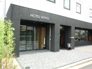 a black building with a hotel wing sign on it at Hotel Wing International Himeji in Himeji