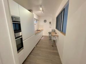 una cocina con paredes blancas y un pasillo largo en L'IDEAL 112 - 85m2, 2 chambres, Parking & Cabine de plage, en Deauville