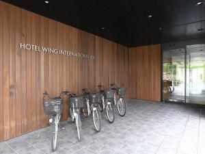une rangée de vélos garés devant un bâtiment dans l'établissement Hotel Wing International Himeji, à Himeji