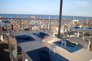two tables and chairs on a balcony with the ocean at Torre Del Sole in Terracina