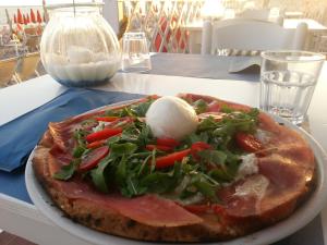 a pizza sitting on a plate on a table at Torre Del Sole in Terracina