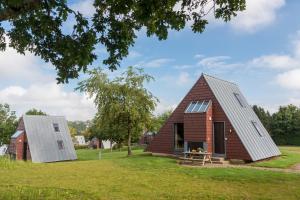 a barn conversion with a metal roof and a red brick house at Zentrum Worriken Holiday Cottages in Butgenbach