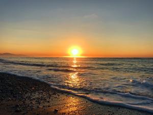 a sunset over the ocean with a beach at Torre Del Sole in Terracina