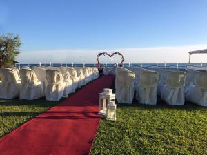 a row of white chairs and a red carpet at Torre Del Sole in Terracina