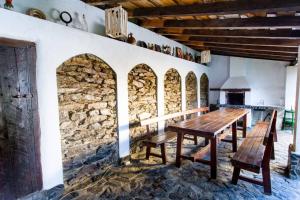 Casa Sub Magrin في Satu Bătrîn: غرفة طعام مع طاولة وكراسي خشبية