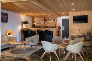 a living room with a bar with chairs and a couch at Chalet Les Rhodos in Cordon