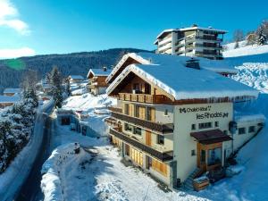 un edificio con nieve en el techo. en Chalet Les Rhodos en Cordon