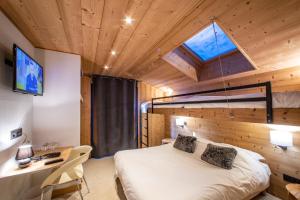 1 dormitorio con cama, escritorio y ventana en Chalet Les Rhodos en Cordon