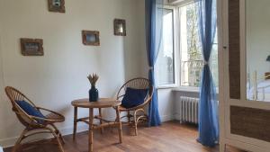 a room with a table and two chairs and a window at Cosy Er Lann Gîte Séquoïa in Val Couesnon