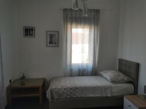 um pequeno quarto com uma cama e uma janela em Apartmani Nika em Rijeka