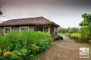 uma pequena casa no meio de uma estrada de terra em Bigfoot Stay - Forganic Farm & Agro Tourism em Khopoli