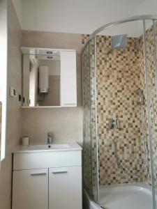 uma casa de banho com um chuveiro e um lavatório. em Apartmani Nika em Rijeka