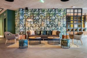 a lobby with a couch and two tables and chairs at The Patio Suite Hotel in Albufeira