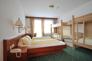 a bedroom with two bunk beds and a desk at Salzburgerhof Jugend- und Familienhotel in Lofer