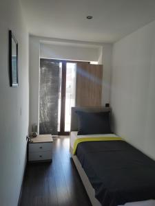 a bedroom with a bed and a large window at Apartmani Nika in Rijeka