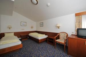 a hotel room with two beds and a tv at Salzburgerhof Jugend- und Familienhotel in Lofer